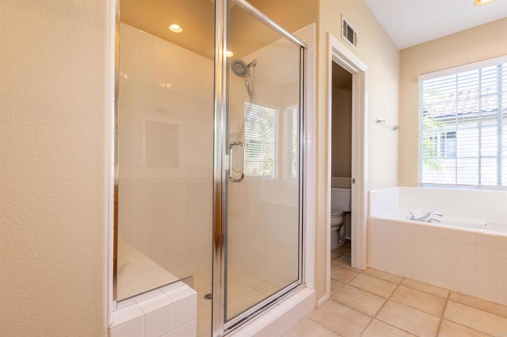7189 Tanager Drive Carlsbad, CA 92011 - Photo 20 of 31 a bathroom with a bathtub and a shower