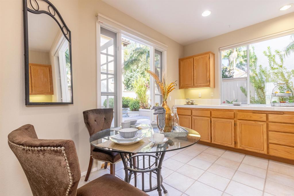 7189 Tanager Drive Carlsbad, CA 92011 - Photo 10 of 31 a kitchen with a table chairs and wooden cabinets