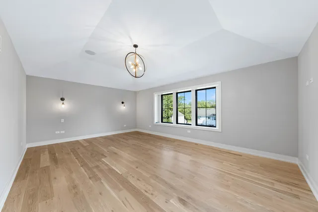 a view of empty room with wooden floor and window