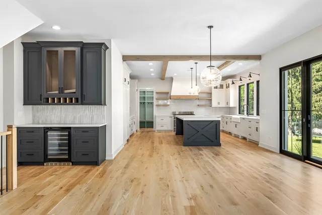 an open kitchen with granite countertop kitchen island wooden floor center island and stainless steel appliances