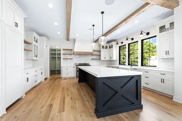 a large kitchen with cabinets wooden floor and stainless steel appliances