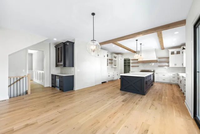 a large kitchen with kitchen island a sink wooden floor and stainless steel appliances