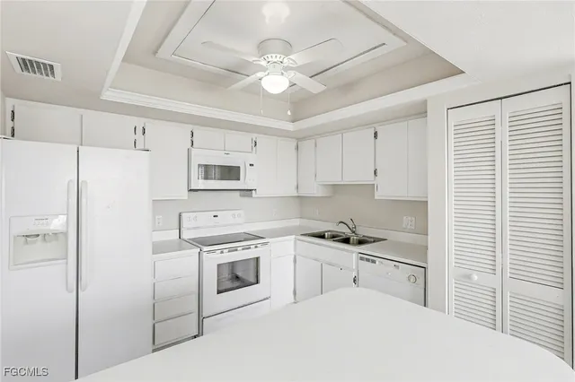 a kitchen with white cabinets and white appliances
