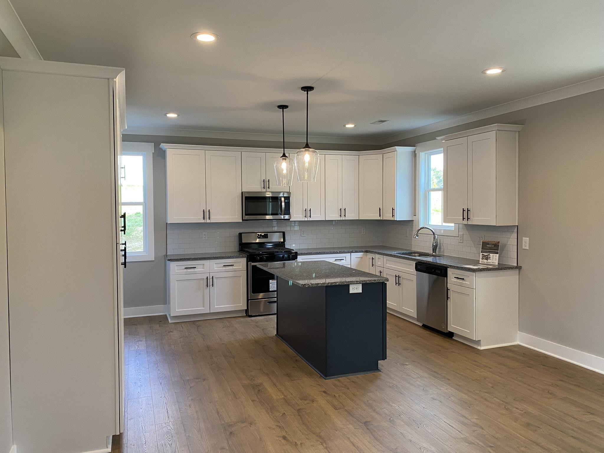 75 Buckstone Place Willow Spring, NC 27592 - Photo 5 of 32 a kitchen with stainless steel appliances granite countertop a stove a sink dishwasher a refrigerator and white cabinets with wooden floor