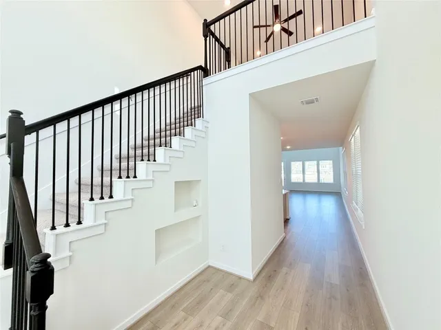 a view of a hallway with wooden floor and staircase