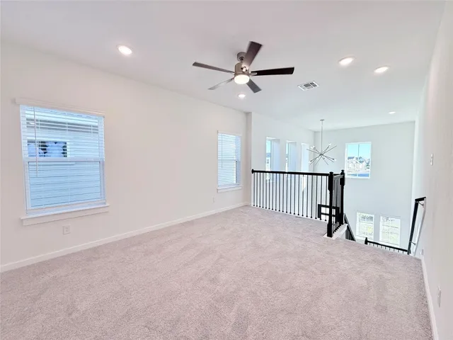 a view of a hallway with a ceiling fan