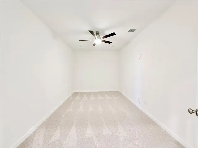a view of empty room with ceiling fan