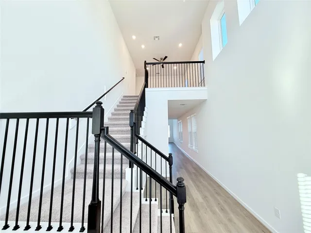 a view of staircase with railing and white walls