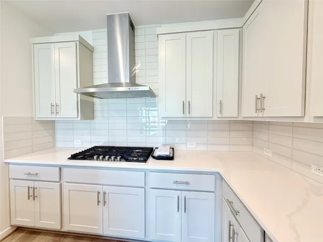 a kitchen with white cabinets and a stove