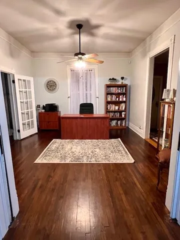 a view of a livingroom with furniture wooden floor front door and windows