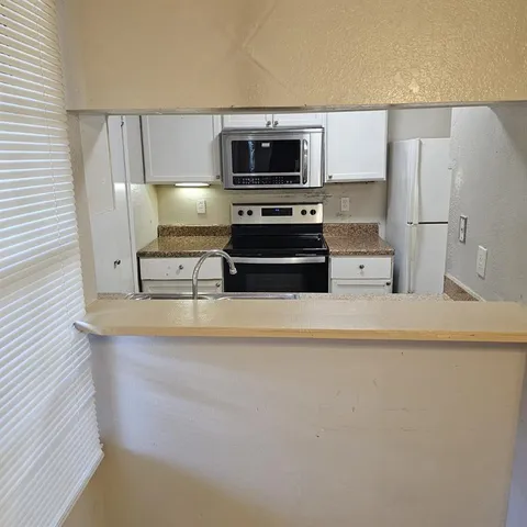 a kitchen with appliances a sink and a microwave