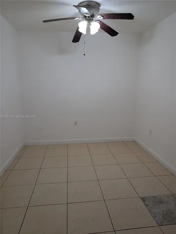 a view of an empty room with a chandelier fan