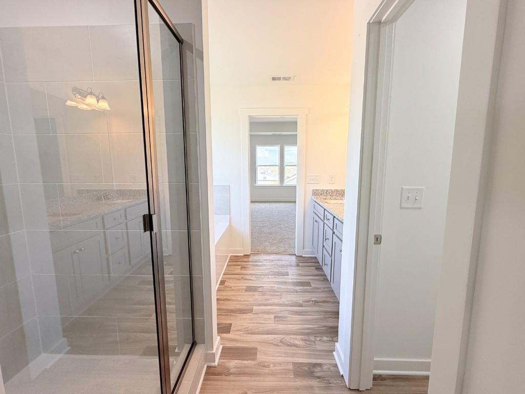 123 Purackal Lane Statham, GA 30666 - Photo 20 of 49 a view of a hallway with wooden floor and a bathroom
