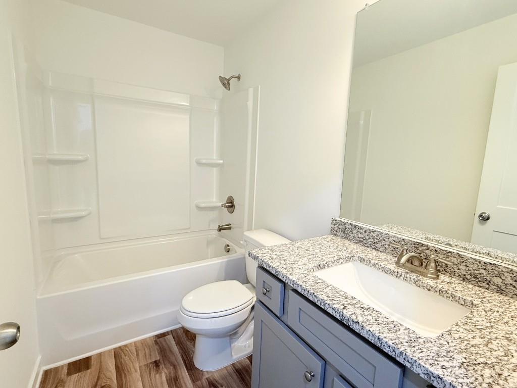 123 Purackal Lane Statham, GA 30666 - Photo 24 of 49 a bathroom with a granite countertop sink a toilet and bathtub