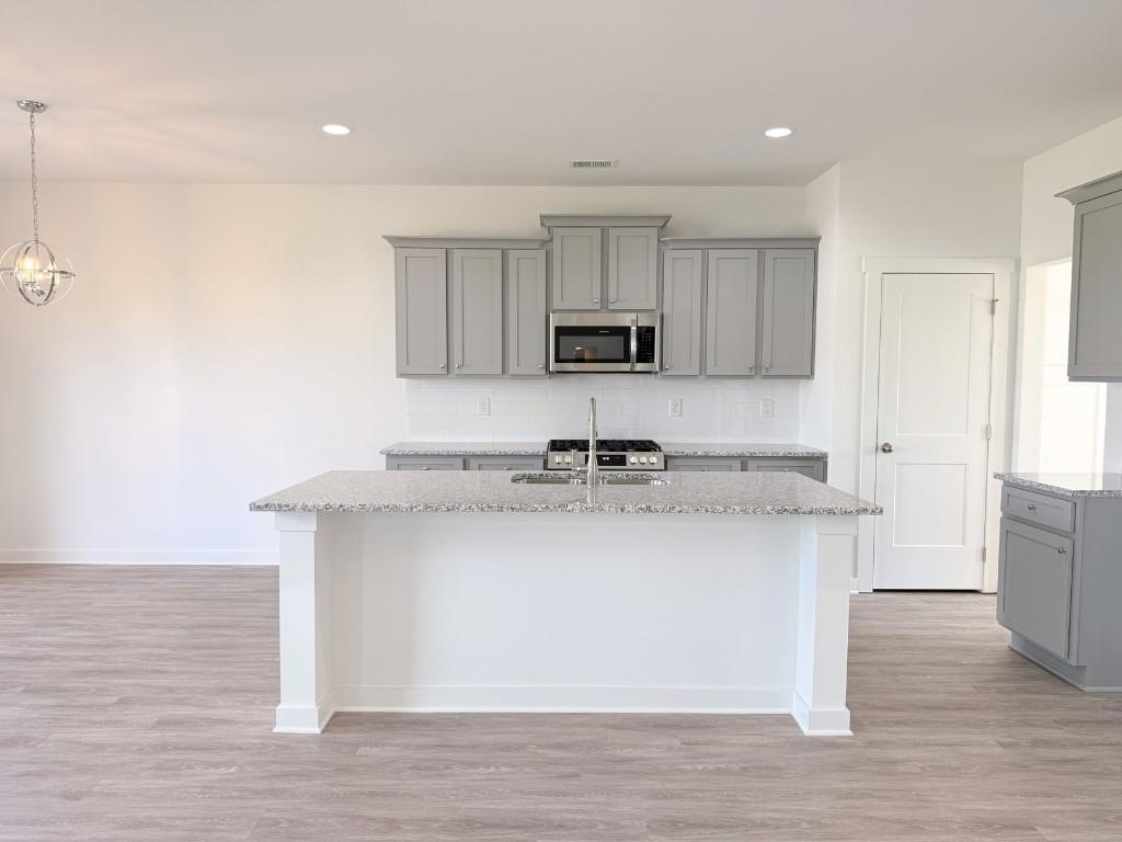 123 Purackal Lane Statham, GA 30666 - Photo 6 of 49 a kitchen with kitchen island a sink a stove a refrigerator and white cabinets