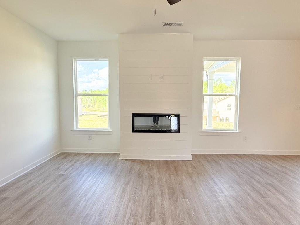 123 Purackal Lane Statham, GA 30666 - Photo 10 of 49 a view of an empty room with wooden floor and a window