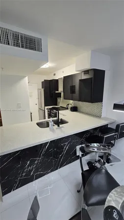 a kitchen with a counter space a sink a stove and a refrigerator