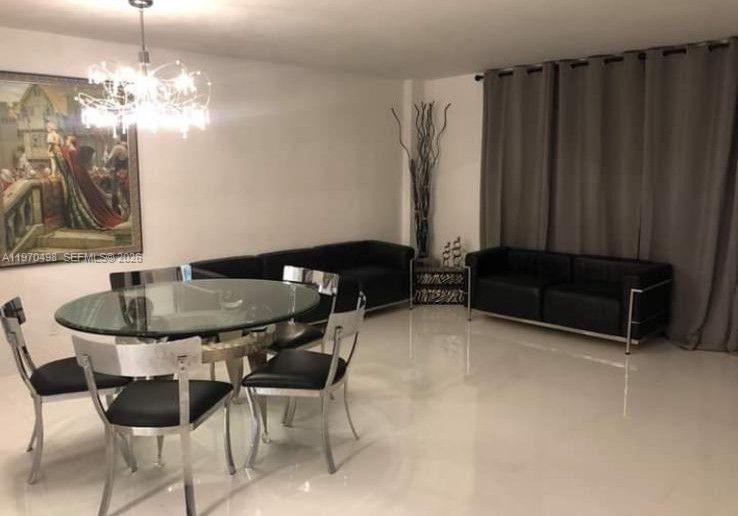 9195 Collins Avenue, Unit 406 Surfside, FL 33154 - Photo 5 of 12 a table and chairs in a room
