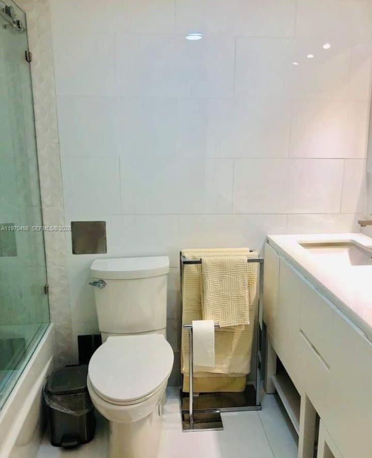9195 Collins Avenue, Unit 406 Surfside, FL 33154 - Photo 7 of 12 a bathroom with a toilet and a sink