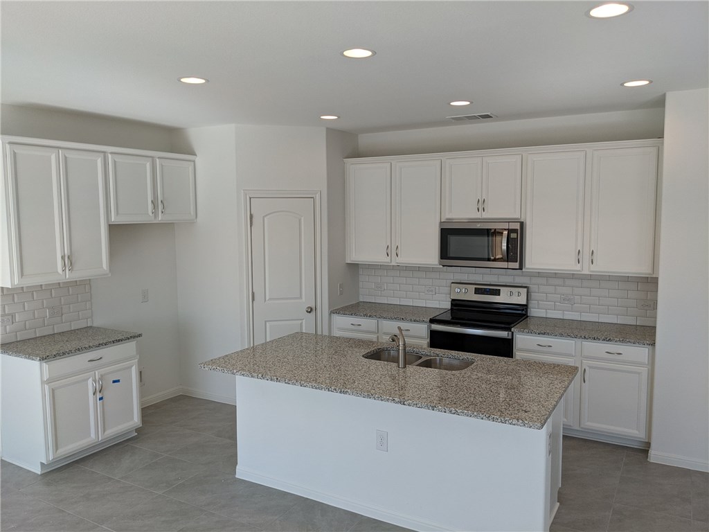 6705 Routenburn Street Austin, TX 78754 - Photo 4 of 18 a kitchen that has a sink and a stove in it