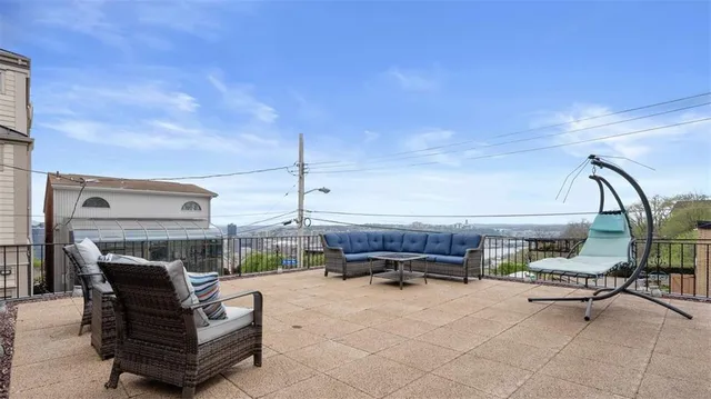 a view of a patio with couches and table and chairs and potted plants