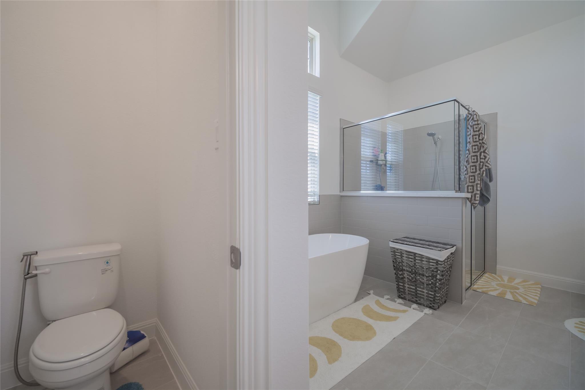 3049 Sage Ranch Drive Leander, TX 78641 - Photo 13 of 23 Indulge in this well-appointed bath, offering both a standalone soaking tub and a spacious glass-enclosed shower.