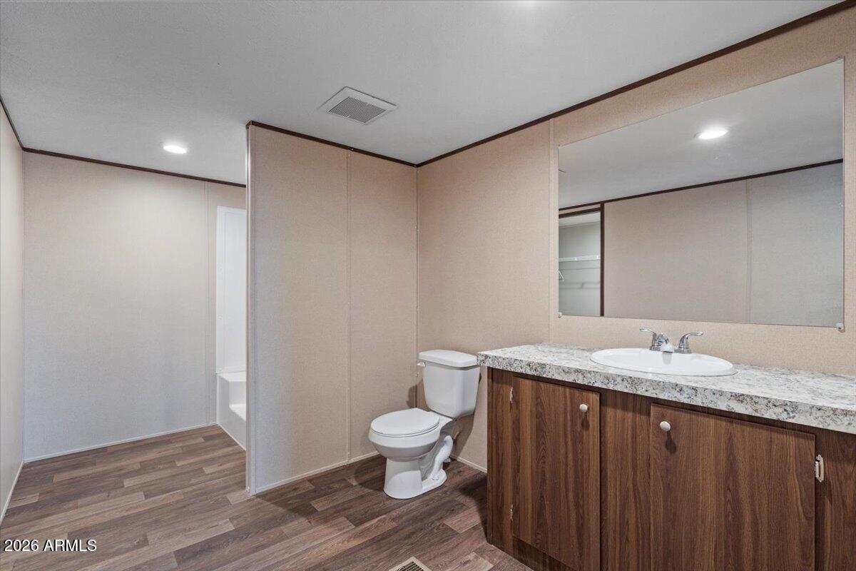 53512 West Organ Pipe Road Maricopa, AZ 85139 - Photo 23 of 44 a bathroom with a granite countertop sink a toilet and a mirror