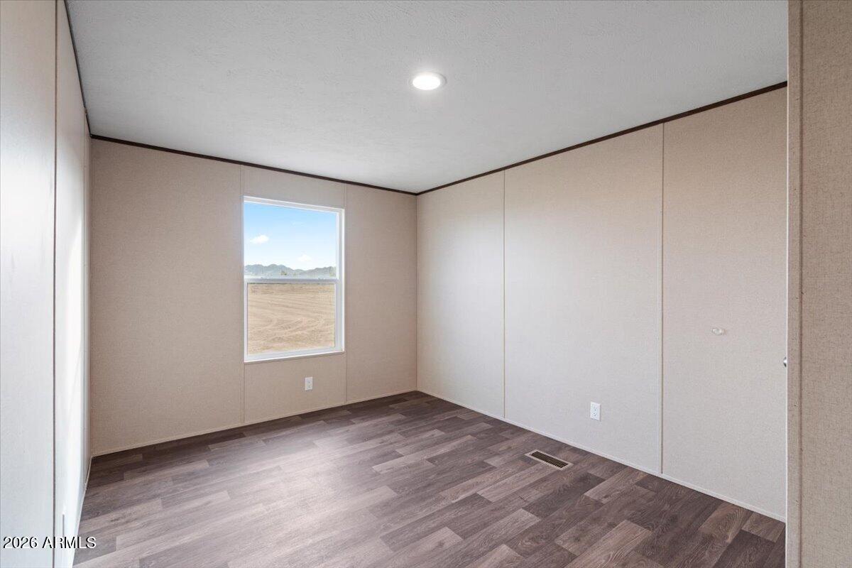 53512 West Organ Pipe Road Maricopa, AZ 85139 - Photo 35 of 44 an empty room with wooden floor and windows