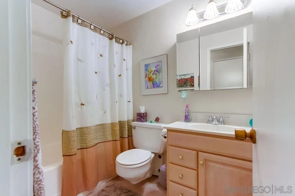 9140 Inverness Road Santee, CA 92071 - Photo 20 of 41 a bathroom with a sink a toilet and shower curtain
