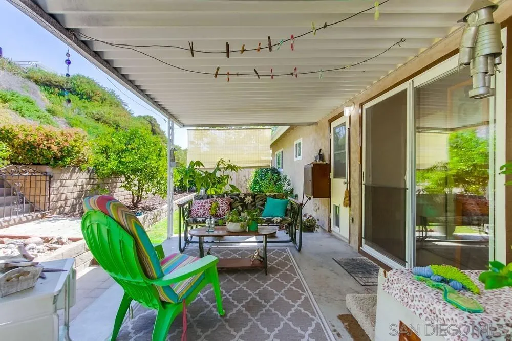 9140 Inverness Road Santee, CA 92071 - Photo 32 of 41 a view of a patio with table and chairs potted plants with floor to ceiling window and wooden fence