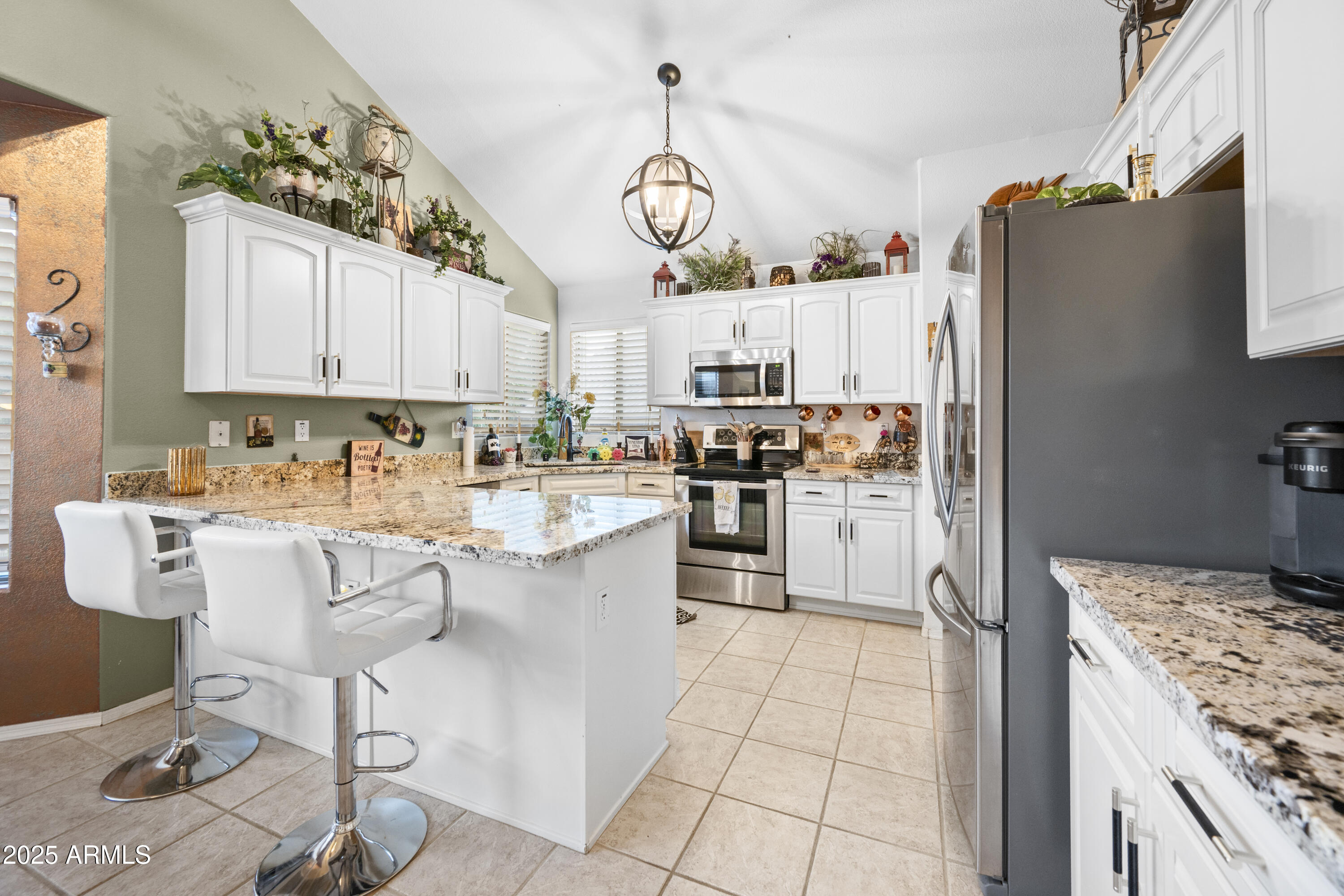 6419 West Briles Road Phoenix, AZ 85083 - Photo 8 of 28 a kitchen with kitchen island granite countertop a stove a sink a dining table and chairs