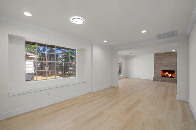 a view of an empty room with a window and a fireplace