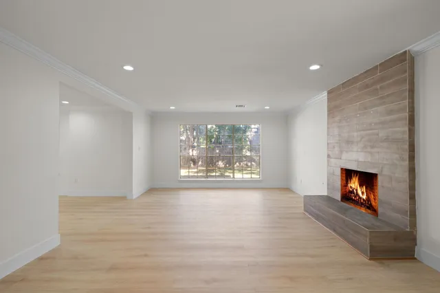a view of an empty room with a fireplace and a window