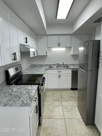a kitchen with stainless steel appliances granite countertop a sink stove and refrigerator