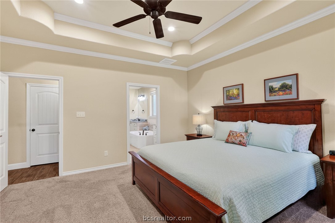 2004 Lexi Lane Bryan, TX 77807 - Photo 18 of 47 a bedroom with a large bed and a chandelier