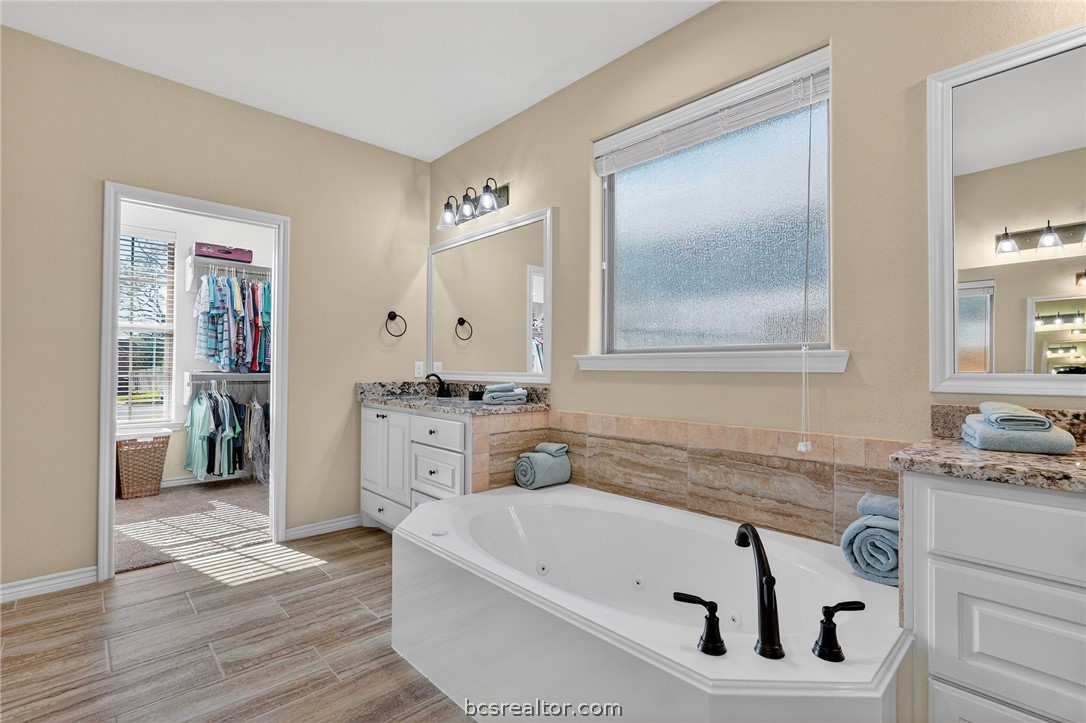 2004 Lexi Lane Bryan, TX 77807 - Photo 26 of 47 a bathroom with a tub sink and mirror