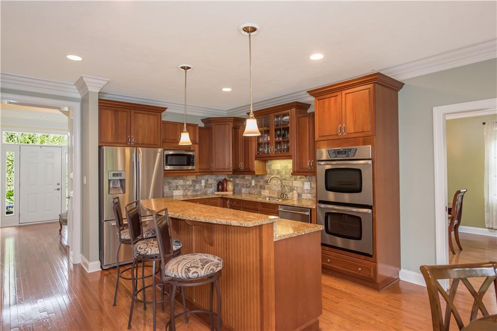 2019 Condor Lane Gibsonia, PA 15044 - Photo 11 of 39 a kitchen with a refrigerator a stove top oven a sink dishwasher and white cabinets with wooden floor