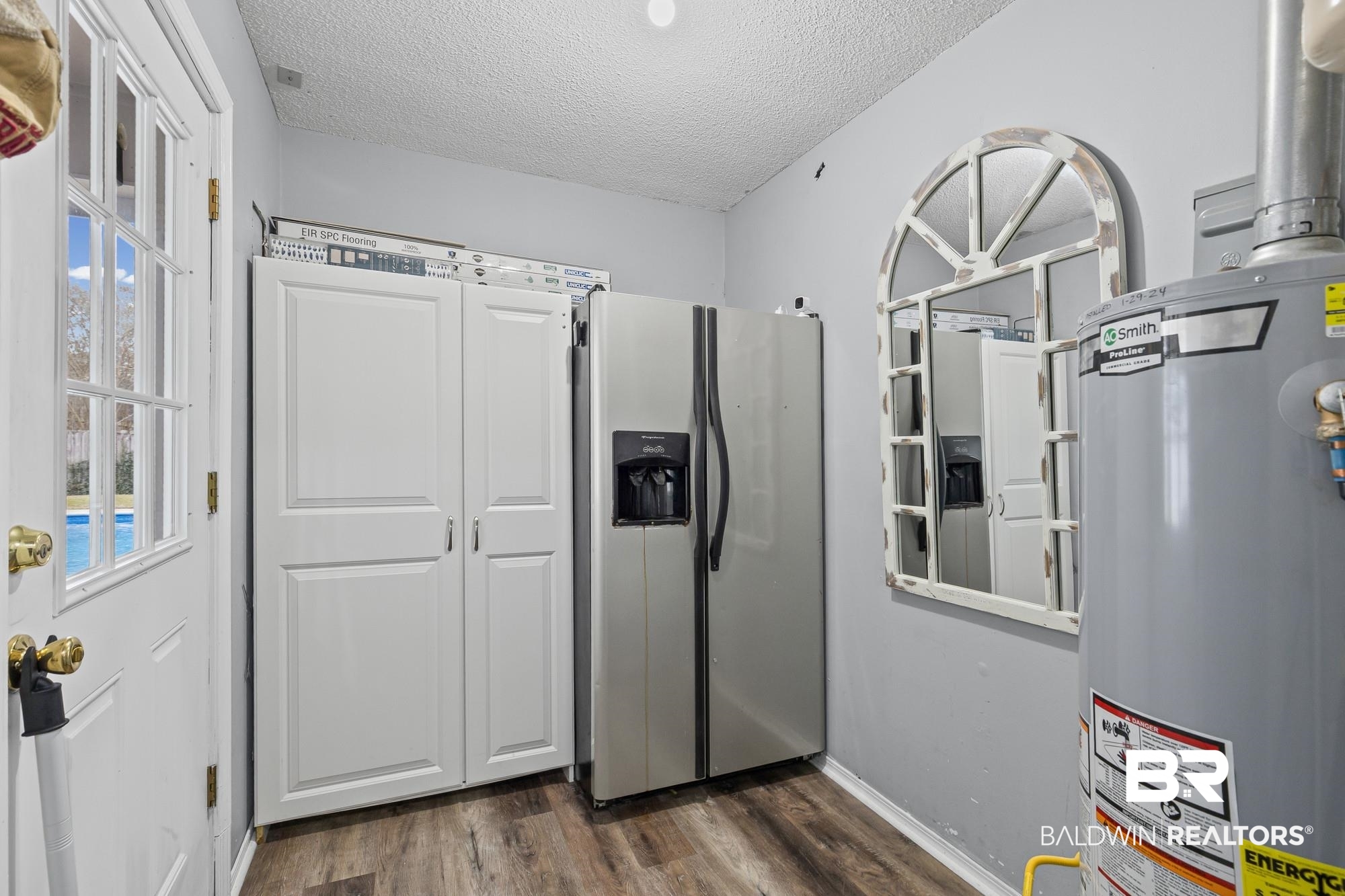 6609 Blakeley Court Mobile, AL 36695 - Photo 10 of 28 Kitchen featuring stainless steel fridge with ice dispenser, water heater, dark wood finished floors, and a textured ceiling