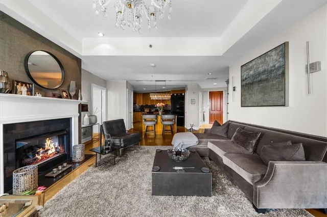 a living room with furniture a fireplace and a chandelier