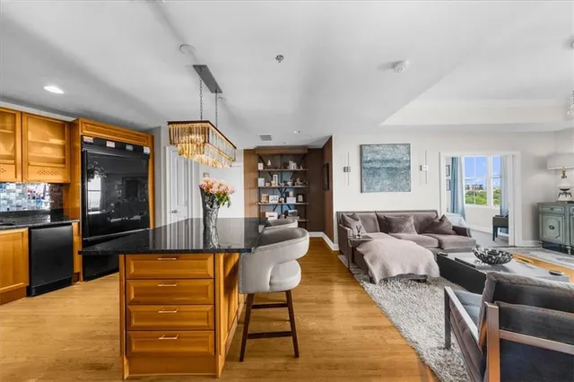 a kitchen with granite countertop wooden floors stainless steel appliances and shower