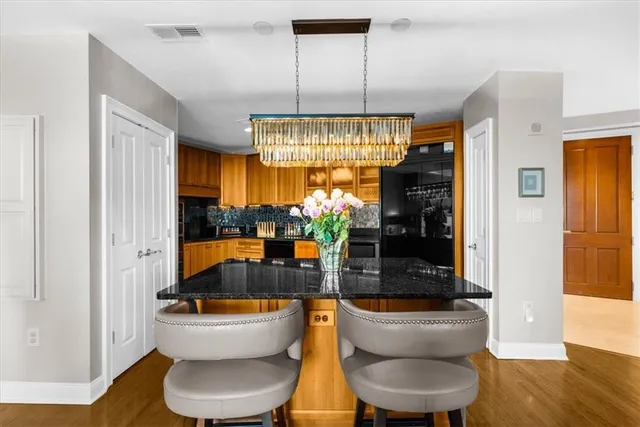 a kitchen with stainless steel appliances granite countertop a sink a stove and a wooden floors