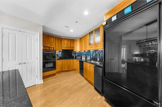 a kitchen with stainless steel appliances granite countertop a sink and a refrigerator