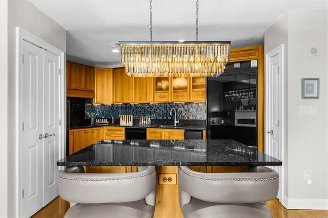 a spacious bedroom with a bed a couch and a flat tv screen on dresser