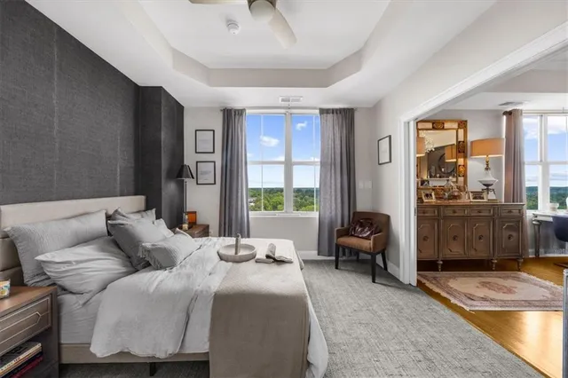 a living room with furniture a chandelier and a floor to ceiling window