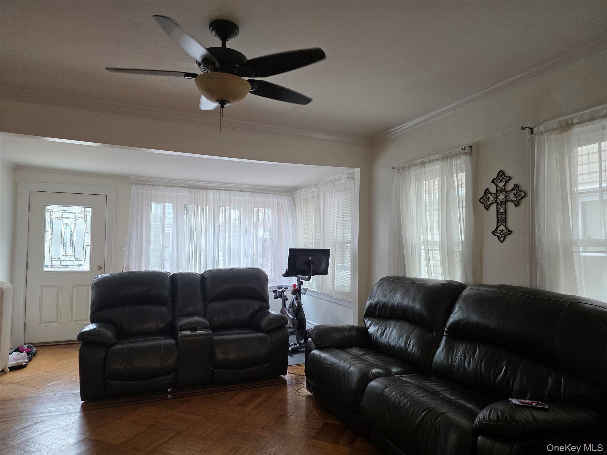 79-49 77th Road Queens, NY 11385 - Photo 2 of 12 Living room featuring crown molding and a ceiling fan