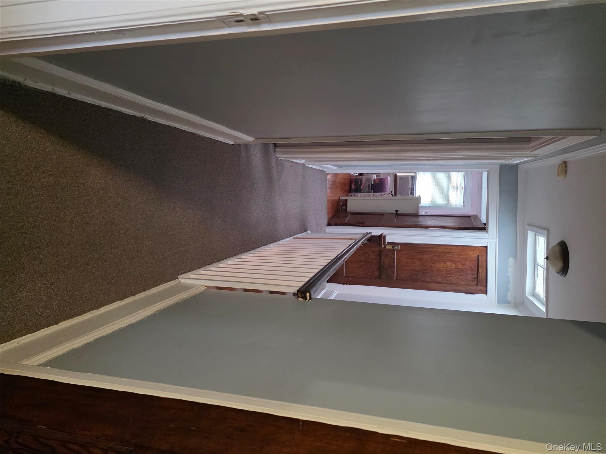 79-49 77th Road Queens, NY 11385 - Photo 6 of 12 Corridor with dark colored carpet and crown molding