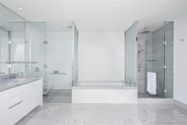 a large white room with a large window and kitchen view