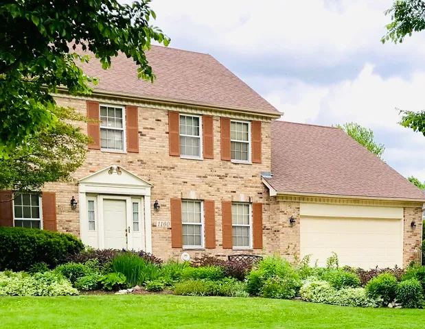 a front view of a house with a yard covered in snow
