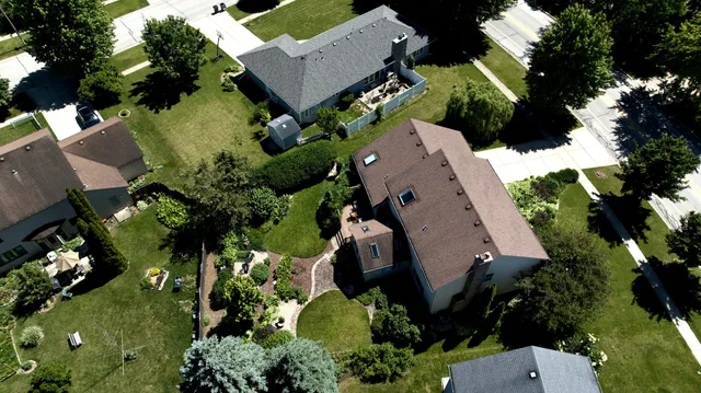 an aerial view of a house with yard and green space