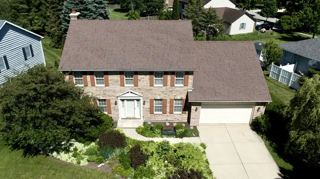 a front view of a house with a yard and potted plants